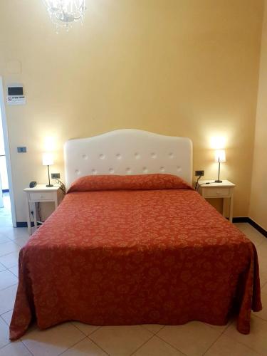 a bedroom with a bed with a red comforter and two lamps at Hotel La Vela-Castello Il Rifugio in Santa Margherita Ligure