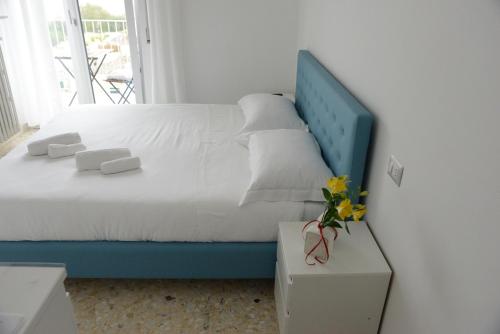 a bed with a blue headboard in a room at Dimore Pietrapenta Apartments, Suites & Rooms - Via Lucana 223, Via Piave 23, Via Chiancalata 16, Vico Fornaci 9 in Matera