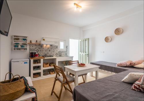 a room with two beds and a table and a kitchen at Krystalia's Apartment in Plaka Milou