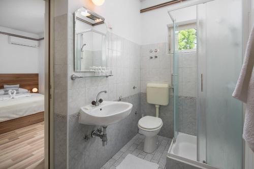 W łazience znajduje się umywalka, toaleta i prysznic. w obiekcie Pansion Anđelko w mieście Starigrad-Paklenica