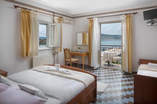 a hotel room with two beds and a balcony at Pansion Anđelko in Starigrad-Paklenica