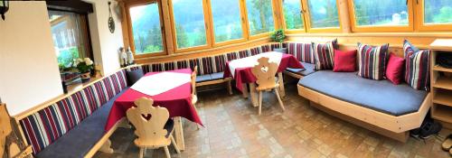 a restaurant with a couch and a table and chairs at Haus Hochzeigerblick in Wenns