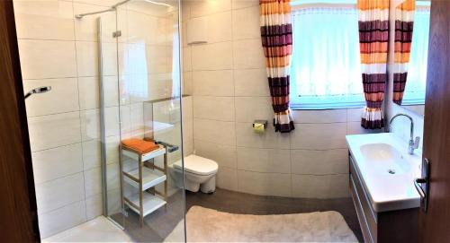 uma casa de banho com um chuveiro, um WC e um lavatório. em Haus Hochzeigerblick em Wenns