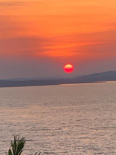 a sunset over the water with the sun in the sky at Hotel Aurora in Flores