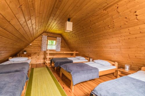 a room with three beds in a wooden cabin at Domki na Leśnej in Sztutowo