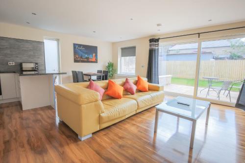 sala de estar con sofá y mesa en Stylish Modern Newly Built Apartment 15 min From City Centre, en Edimburgo