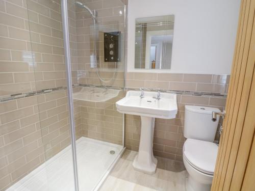 Un baño con inodoro, lavabo y ducha. en 14 Tudno Street, en Llandudno