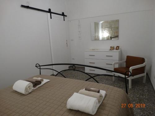 a bedroom with a bed with towels and a chair at La Casetta di Ninella in Polignano a Mare