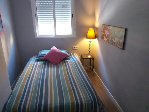 a small bedroom with a bed and a window at Avenue Rooms in Valencia