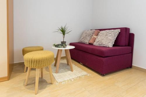 a living room with a purple couch and a table at Emily Apartment in Suđurađ