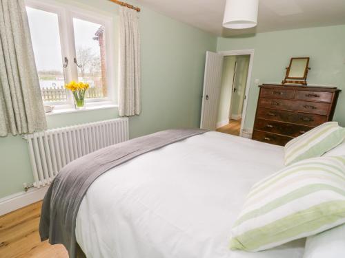 A bed or beds in a room at Wigrams Canalside Cottage