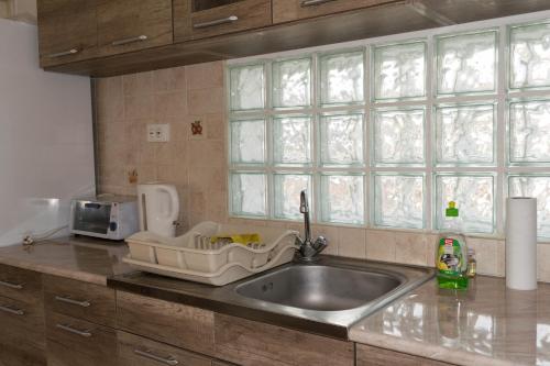 a kitchen counter with a sink and a window at Maria Apartman in Nyíregyháza