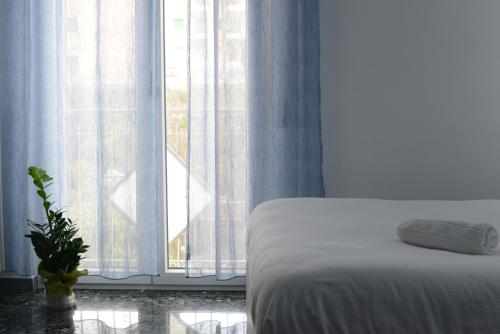a bedroom with a bed and a window with a plant at Dimore Pietrapenta Apartments, Suites & Rooms - Via Lucana 223, Via Piave 23, Via Chiancalata 16, Vico Fornaci 9 in Matera