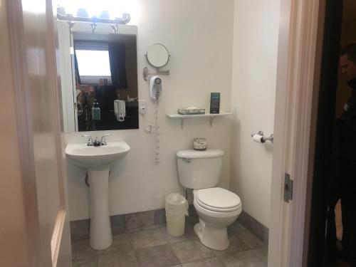 a white bathroom with a toilet and a sink at Century Casino & Hotel Cripple Creek in Cripple Creek