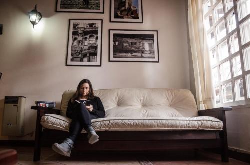 una mujer sentada en un sofá en una habitación en Departamento Loft, en medio de la ciudad en Mendoza