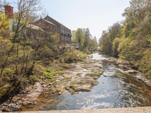 a river next to a building next to a river at 12 Keathbank Court in Blairgowrie
