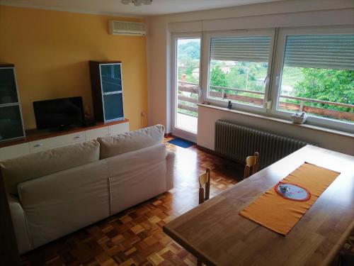 sala de estar con sofá blanco y mesa en Apartma BAJČI, en Ajdovščina