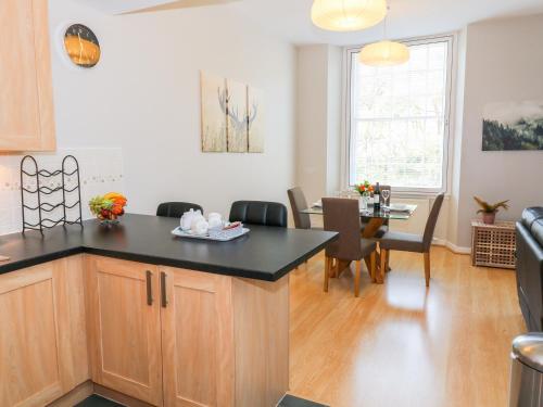 a kitchen and dining room with a kitchen island and a table at 12 Keathbank Court in Blairgowrie