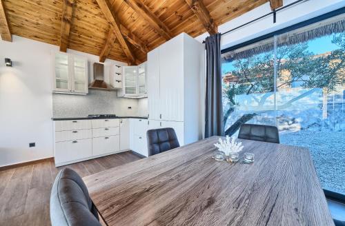 a kitchen and dining room with a wooden table and chairs at Golden Haven Luxe Bungalow Resort in Murter