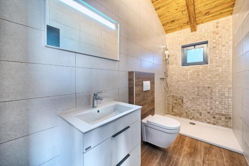 a bathroom with a sink and a toilet at Golden Haven Luxe Bungalow Resort in Murter