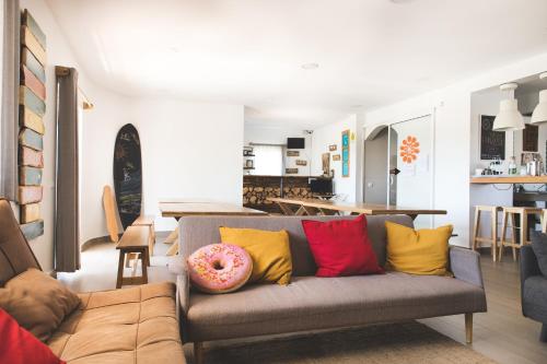 una sala de estar con un sofá con una rosquilla. en Good Feeling Hostel & Guest House, en Raposeira