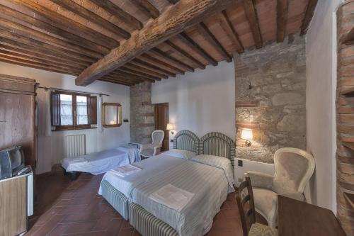 een slaapkamer met 2 bedden en een tafel en stoelen bij Relais Santa Cristina in Radda in Chianti