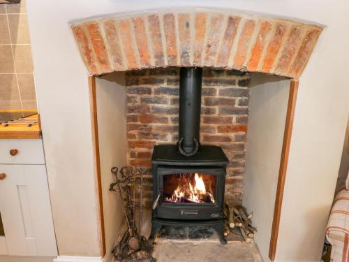 a stove in a brick fireplace in a kitchen at 5 Oystons Yard in Whitby