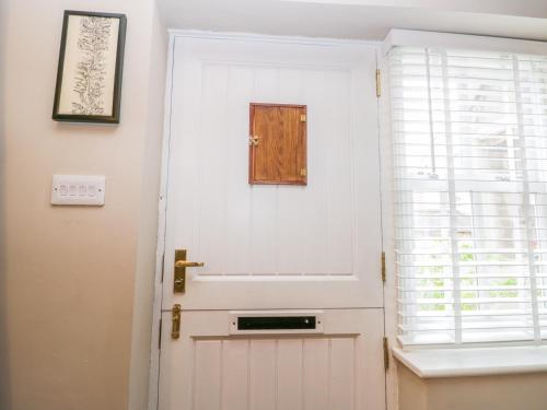 a white door in a room with a window at 5 Oystons Yard in Whitby