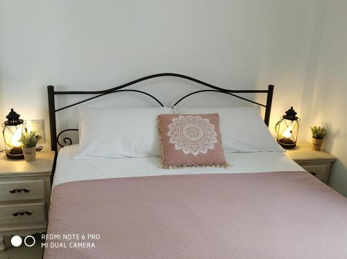 Una cama con marco negro y una almohada rosa. en Il Silenzio, en Magarikárion