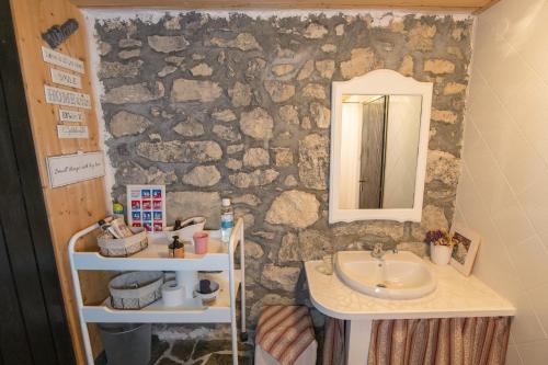 a bathroom with a sink and a stone wall at Slabnik Nature Escape in Idrija