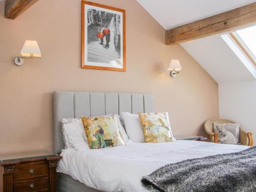 a bedroom with a bed with white sheets and pillows at Vitula Cottage in Shrewsbury