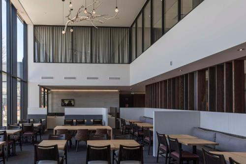 a restaurant with tables and chairs and windows at Hôtel & Suites Normandin Lévis in Lévis