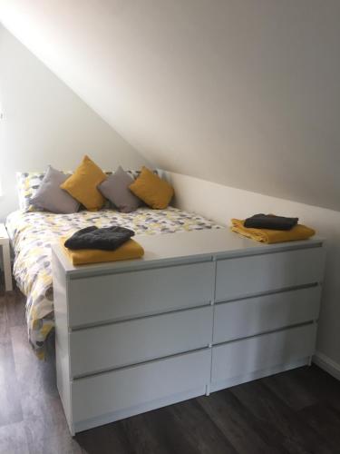 a bedroom with a white bed with yellow pillows at The Tree House in Inverness