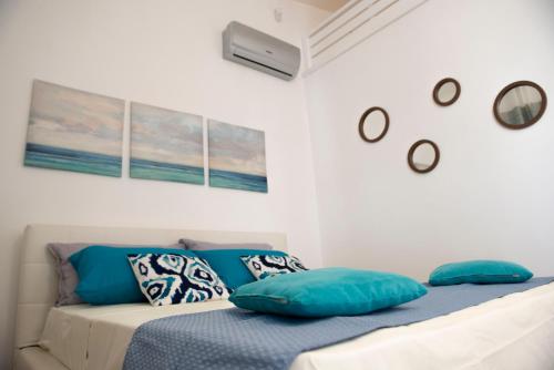a bedroom with a bed with blue pillows at Le Casette di Alice in Scoglitti