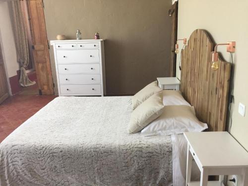 a bedroom with a white bed and a dresser at Le Temps d'un Rêve in Mazan