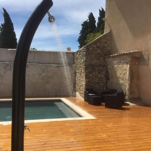 a swimming pool with a water fountain at Le Temps d'un Rêve in Mazan
