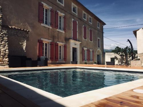 a swimming pool in front of a building at Le Temps d'un Rêve in Mazan