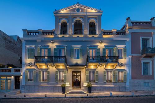 un grand bâtiment blanc avec une tourelle dans l'établissement Syrou Melathron, à Ermoúpoli