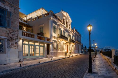 uma rua de calçada com edifícios brancos à noite em Syrou Melathron em Ermoupoli