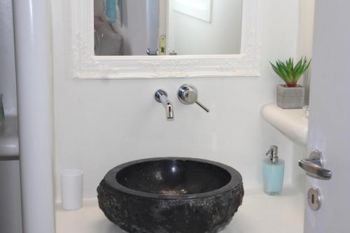 a bathroom with a black bowl sink on a counter at Studios Betty in Plaka Milou