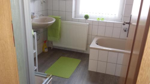 a small bathroom with a sink and a tub at Ferienhaus FRIESENNEST in Norden