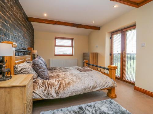 a bedroom with a bed and a brick wall at Moscow Mews in Bradford