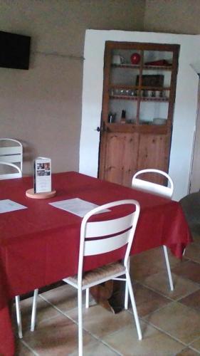 a red table with white chairs and a red table cloth at Le Temps d'un Rêve in Mazan