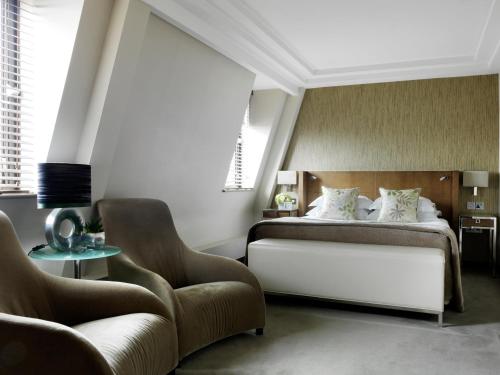 a bedroom with a bed and a chair at The Marylebone Hotel in London