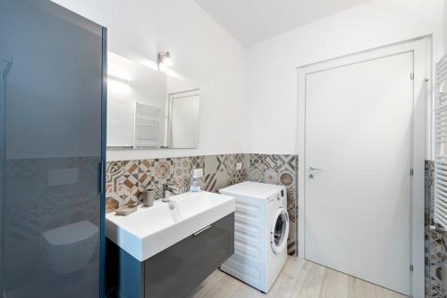 a bathroom with a sink and a washing machine at Casa Bella in Argegno