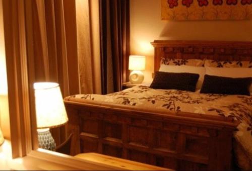 a bedroom with a bed and a lamp and a mirror at Malin TownHouse in Malin