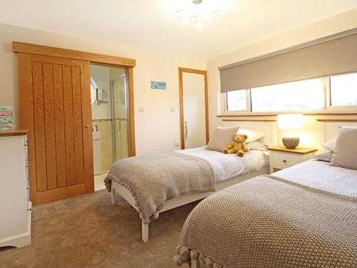 a bedroom with two beds and a teddy bear on the bed at The Bay in Trearddur