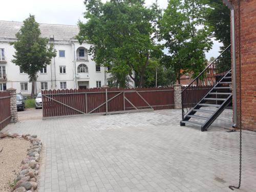 a fence with a staircase in front of a building at Centras in Kėdainiai