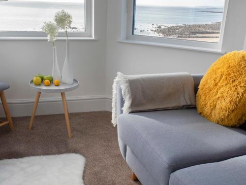 a living room with a couch and a table with fruit at The Towers - Ardudwy in Criccieth