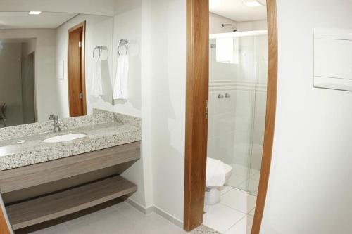 a bathroom with a sink and a shower at Prive Atrium Thermas Residence in Caldas Novas